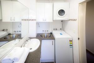 a kitchen with a sink, stove, and refrigerator at Aussie Resort in Gold Coast