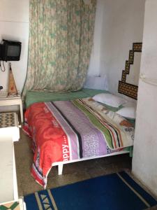 a bed in a room with a blanket on top of it at Hôtel Sindbad in Houmt Souk