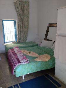 1 dormitorio con 2 camas y ventana en Hôtel Sindbad en Houmt El Souk