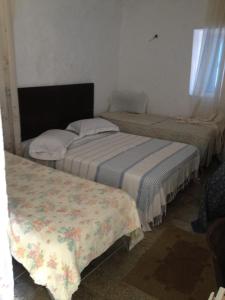 2 camas individuales en una habitación con ventana en Hôtel Sindbad en Houmt El Souk