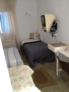 a small room with two beds and a desk at Hôtel Sindbad in Houmt Souk