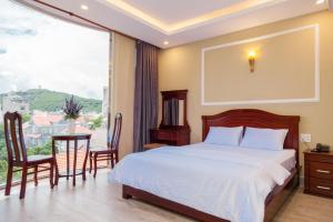 1 dormitorio con 1 cama, mesa y sillas en Sea Memory Hotel, en Vung Tau