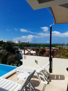 a pair of lounge chairs on the roof of a building at Casa Linda Isla-Room Palmera-Shared Pool in Isla Mujeres