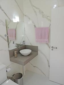 bagno bianco con lavandino e specchio di POUSADA AZALÉIAS a Florianópolis