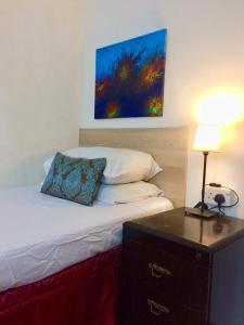 a bedroom with a bed with a lamp and a painting on the wall at Low Budget SingleBed Bedroom in Kuala Lumpur