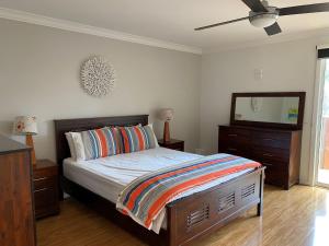 a bedroom with a bed with a dresser and a television at Melandy Main House in Inverloch
