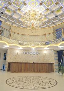 a large room with a chandelier and a stage at Grand Ark Bukhara in Bukhara