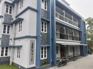 a blue and white building with a motorcycle parked in front at Wayanad Vista Service Apartment in Wayanad