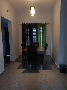 a dining room with a wooden table and chairs at Wayanad Vista Service Apartment in Wayanad