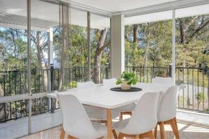 une salle à manger blanche avec une table blanche et des chaises blanches dans l'établissement Leura Sublime Sunrise, à Leura