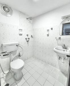 biała łazienka z toaletą i umywalką w obiekcie Cloud 9 Garden w Katmandu