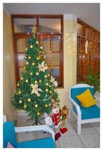 a christmas tree in the corner of a living room at Hospedaje La Casa Blanca in Urbanizacion Buenos Aires