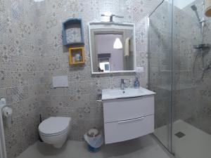 a bathroom with a toilet and a sink and a mirror at B&b Casa Vita Marconia in Marconia