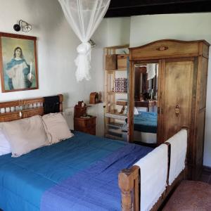a bedroom with a blue bed and a mirror at La Casa del Orobal in Agaete