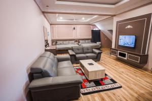 a living room with couches and a flat screen tv at Barrington Villa @ Golden Hill in Cameron Highlands