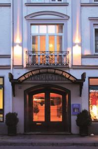 a building with a door and a balcony on top of it at Hotel Wendelstein in Rosenheim