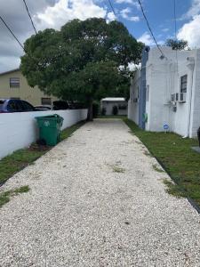 een grindoprit voor een wit huis bij Cozy Private Room, near the Airport - Free parking - 01 in Miami