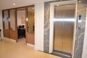 a lobby with a glass elevator in a building at Annex Hotel Tavern in Surigao