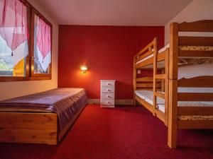 a bedroom with two bunk beds and red walls at Appartement Valmorel, 1 pièce, 4 personnes - FR-1-356-337 in Valmorel