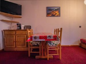 a kitchen with a table and chairs and a television at Appartement Valmorel, 1 pièce, 4 personnes - FR-1-356-337 in Valmorel