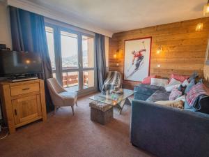 a living room with a couch and a television at Appartement Valmorel, 3 pièces, 4 personnes - FR-1-356-324 in Valmorel