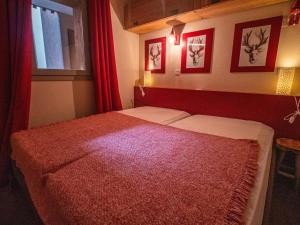 a bedroom with two beds with red curtains and a window at Appartement Valmorel, 3 pièces, 4 personnes - FR-1-356-324 in Valmorel