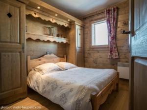 アーク 1801にあるAppartement Les Arcs 1800, 3 pièces, 6 personnes - FR-1-352-6の木製の部屋にベッド1台が備わるベッドルーム1室があります。