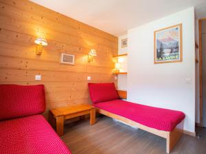 ヴァルモレルにあるAppartement Valmorel, 1 pièce, 4 personnes - FR-1-356-322の赤いベッド2台とベンチが備わる客室です。