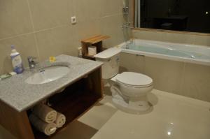a bathroom with a toilet and a sink and a tub at Crystal Beach Bali in Candidasa