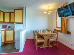 a kitchen and dining room with a wooden table with chairs at Appartement La Plagne, 2 pièces, 6 personnes - FR-1-353-72 in La Plagne