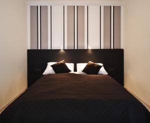 a bedroom with a large bed with two pillows at Design Studios SVI-MI in Zagreb