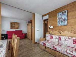 a living room with a bed and a red couch at Appartement Plagne 1800, 2 pièces, 7 personnes - FR-1-351-70 in Plagne 1800