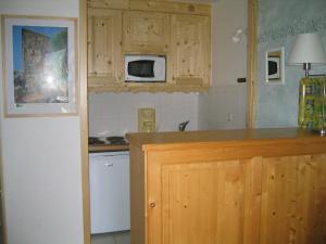 - une cuisine avec des placards en bois et un four micro-ondes dans l'établissement Appartement Méribel, 2 pièces, 5 personnes - FR-1-355-33, à Méribel