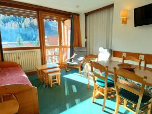 a living room with a table and chairs and a television at Appartement La Plagne, 3 pièces, 6 personnes - FR-1-351-2 in La Plagne