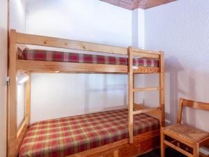 two bunk beds in a small room with a chair at Appartement La Plagne, 3 pièces, 6 personnes - FR-1-353-8 in La Plagne
