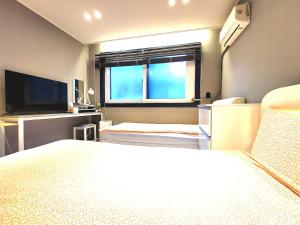 a bedroom with a large bed and a window at Ryu Guest House Gangnam in Seoul