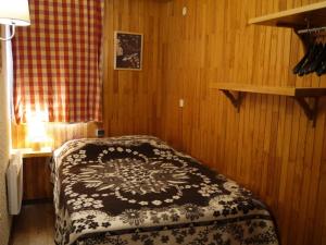 una camera con un letto con una coperta bianca e nera di Appartement Méribel, 2 pièces, 6 personnes - FR-1-355-112 a Méribel