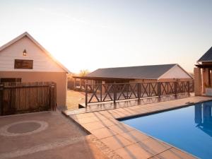 uma casa com piscina ao lado de um edifício em Masingitana Hotel em Acornhoek