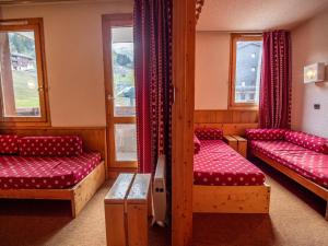 a room with two beds and two windows at Appartement Valmorel, 1 pièce, 4 personnes - FR-1-356-363 in Valmorel