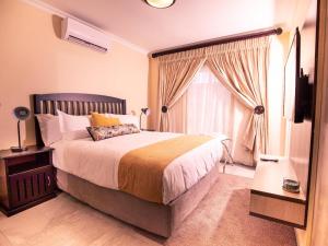 AcornhoekMasingitana Hotel的一间带大床和窗户的卧室