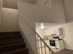 a kitchen with a staircase with a stove and a microwave at Golden Vegas Condo next to Airport & University in Las Vegas