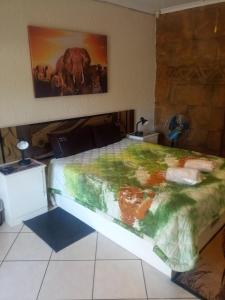 um quarto com uma cama com uma pintura de um elefante em Rock Art Guesthouse em Witbank