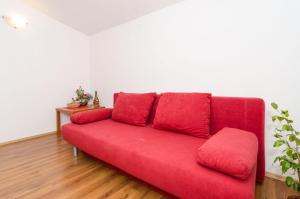 un sofá rojo sentado en una sala de estar en Apartments Žuronja, en Putniković