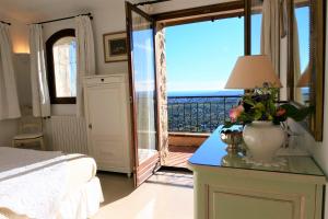 a bedroom with a bed and a view of the ocean at La Bastide des Pins in Vence