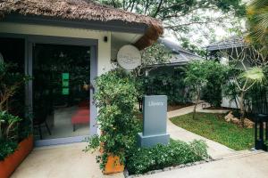 a sign in front of a house with a door at Rocky's Boutique Resort - Veranda Collection Samui in Lamai