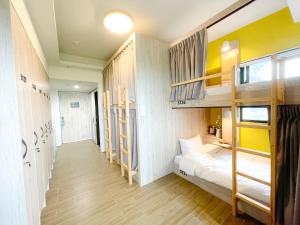 a dorm room with bunk beds and a hallway at Golden W Hotel in Shalu