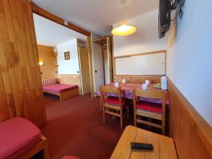 una sala da pranzo con tavolo e sedie e una camera di Appartement La Plagne-Tarentaise, 1 pièce, 4 personnes - FR-1-353-80 a Les Coches