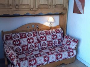 a couch with red and white pillows in a room at Studio Les Deux Alpes, 1 pièce, 4 personnes - FR-1-516-55 in Les Deux Alpes