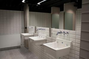 a bathroom with two sinks and two mirrors at Next House Copenhagen in Copenhagen