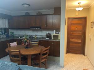 a kitchen with a wooden table and a dining room at JuHouse in Torreira